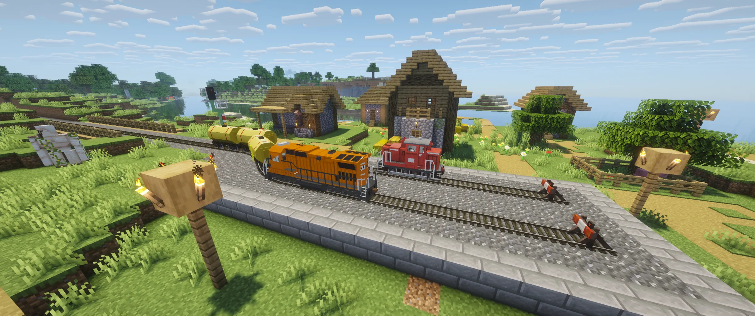 Traincraft on Minecraft 26.2: a diesel locomotive and a red shunter on ballast track next to a village